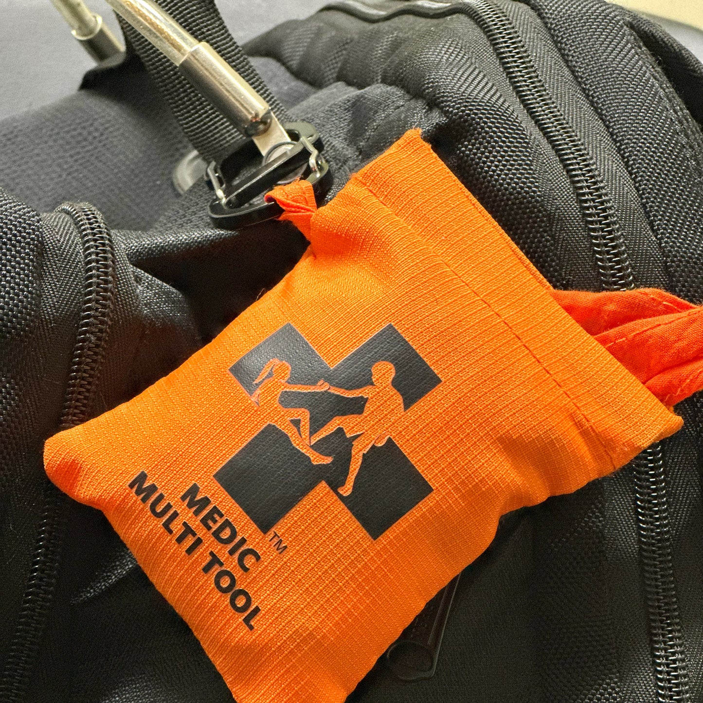 Orange MEDIC Multi Tool pouch attached to a black bag