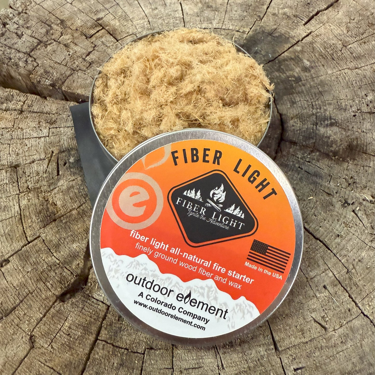 Fiber Light fire starter in round tin on a wooden background