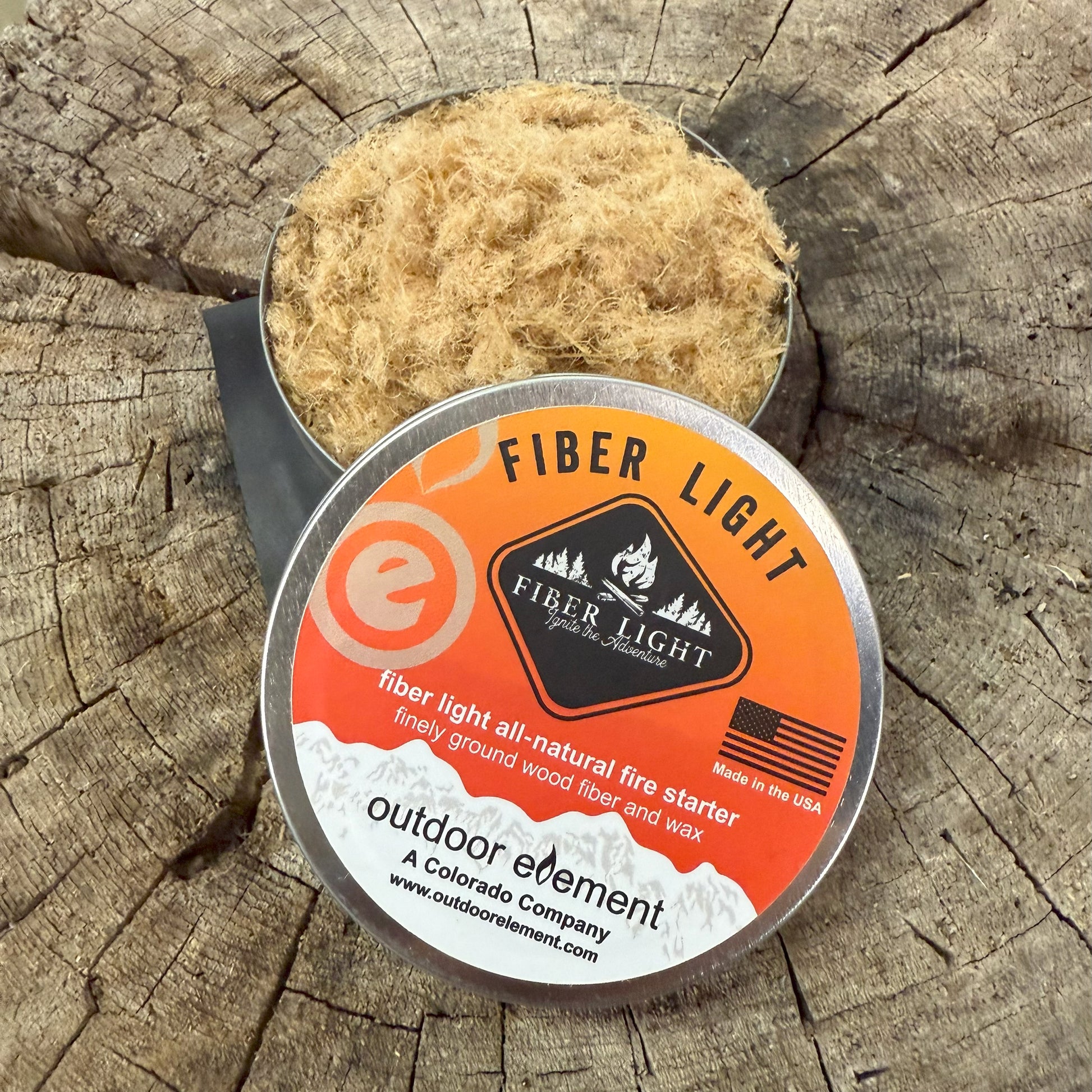 Fiber Light fire starter in round tin on a wooden background
